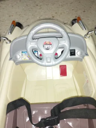 Coche eléctrico para niños, color beige.