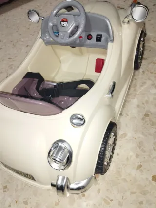 Coche eléctrico para niños, color beige.