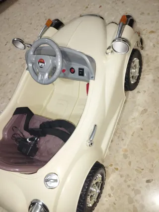 Coche eléctrico para niños, color beige.