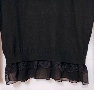 Maglione nero con balza in pizzo sul fondo