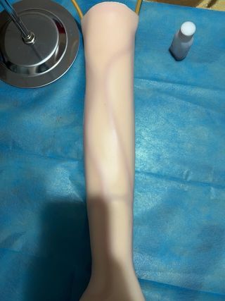 Brazo simulador enfermería con herramientas