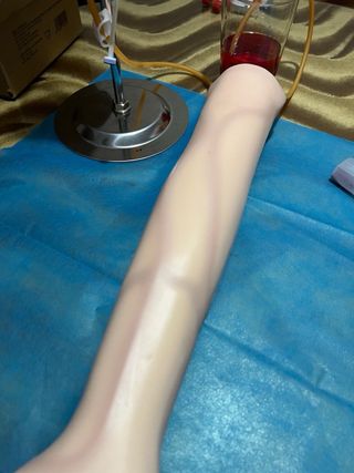 Brazo simulador enfermería con herramientas