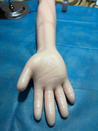 Brazo simulador enfermería con herramientas