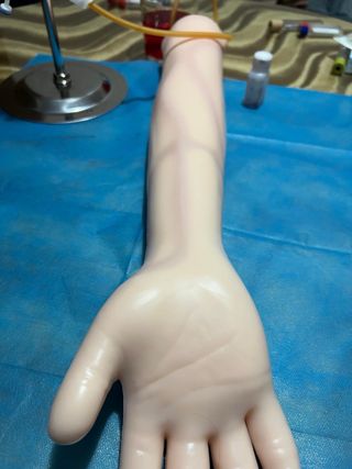 Brazo simulador enfermería con herramientas