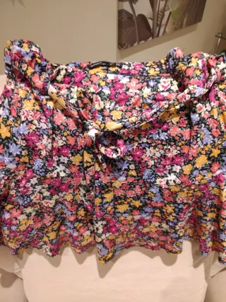 Falda corta vuelo floral con pantalón debajo.