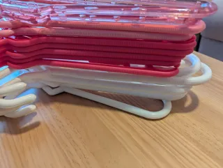 Perchas de plástico grandes rosas y blancas