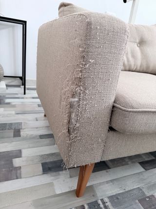 Sofá beige de tela con patas de madera