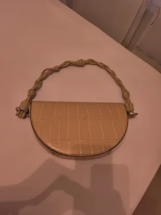 Bolso de mano beige con asa trenzada