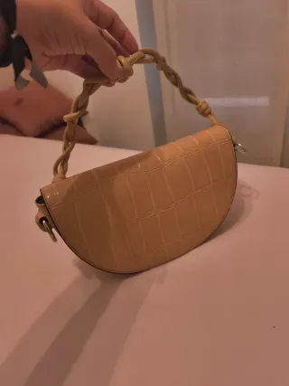 Bolso de mano beige con asa trenzada