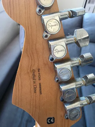 Guitarra Eléctrica Squier Fender negra y altavoz