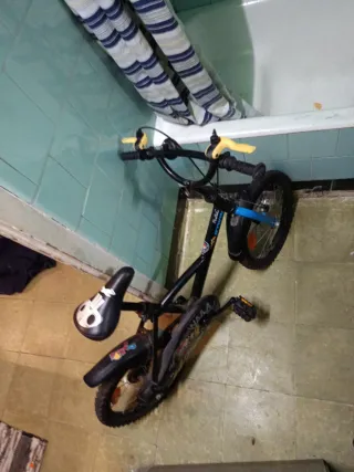 Bicicleta infantil negra con ruedas azules niño
