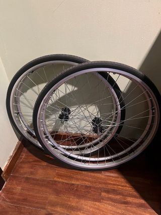 Silla de ruedas con ruedas auxiliares.