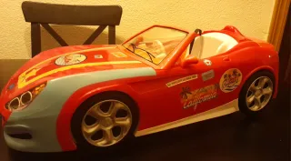 Nancy con patinete y coche descapotable.