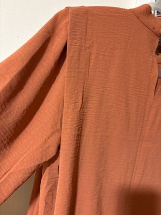 Blusa color teja manga larga con pequeño cuello.