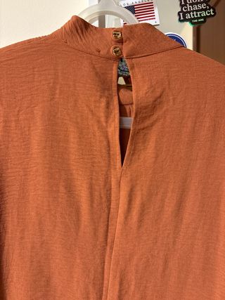 Blusa color teja manga larga con pequeño cuello.