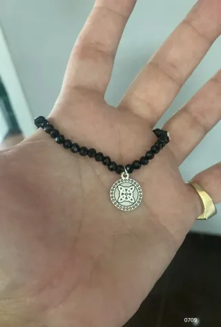 Pulsera negra con dije plateado