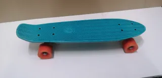 Monopatín azul con ruedas naranjas