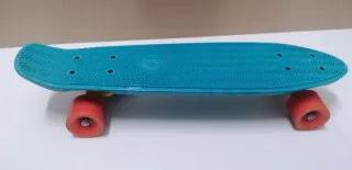 Monopatín azul con ruedas naranjas
