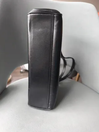 Bolso de cuero negro con logo dorado