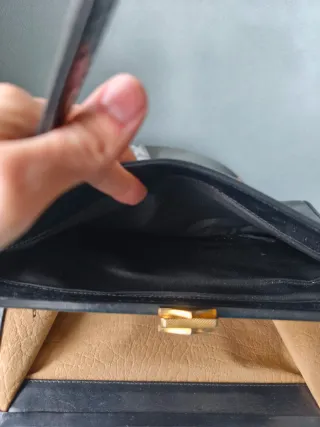 Bolso de cuero negro con logo dorado