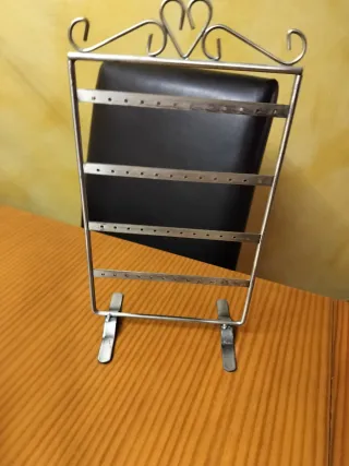 Colgador de pendientes en metal plateado.