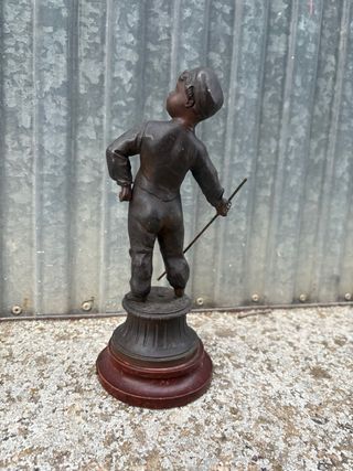 Escultura antigua de niño con bastón