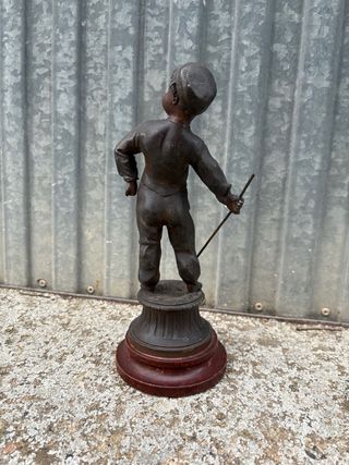 Escultura antigua de niño con bastón