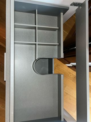 Mueble de baño gris con lavabo sin grifo.