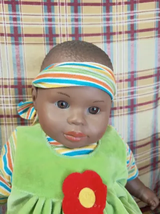 Muñeca bebé con vestido verde y diadema