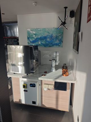 Vending de café con brazo robótico.