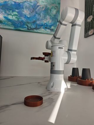 Vending de café con brazo robótico.