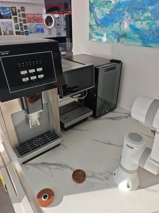 Vending de café con brazo robótico.