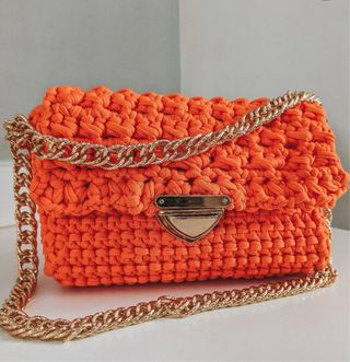 Bolso de malla naranja con cadena dorada