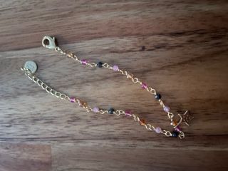 Pulsera dorada con dijes de estrella y cuentas