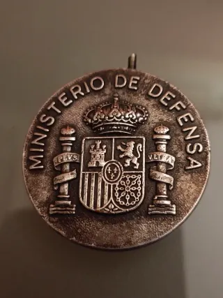 Medalla militar con tanques, barcos y aviones