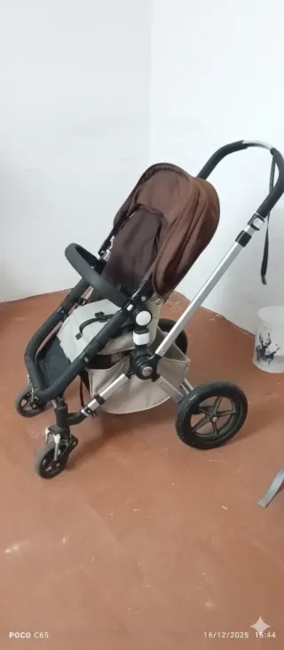 Carro de niño marrón con sillita de coche.