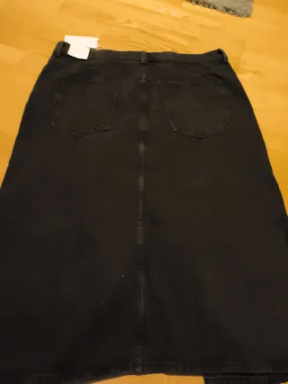 Falda midi vaquera negra. Con abertura delante.