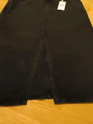 Falda midi vaquera negra. Con abertura delante.