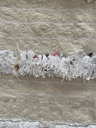 Alfombra beige con flecos y detalles