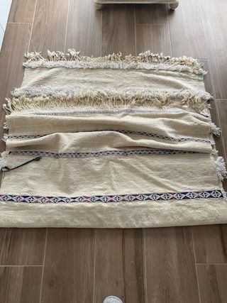 Alfombra beige con flecos y detalles