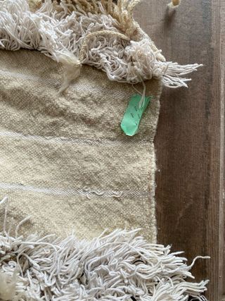 Alfombra beige con flecos y detalles