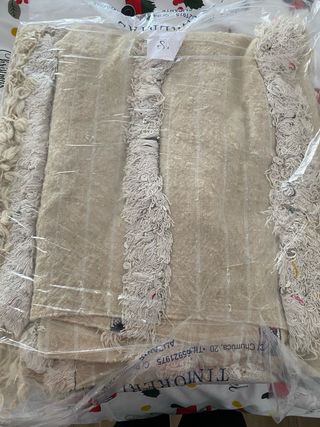 Alfombra beige con flecos y detalles