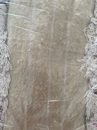 Alfombra beige con flecos y detalles