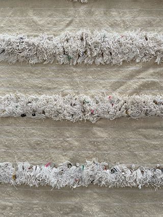 Alfombra beige con flecos y detalles