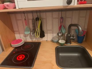 Cocina de juguete con fogones rojos y complementos