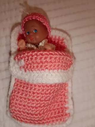 Cuna de mimbre con muñeco y accesorios