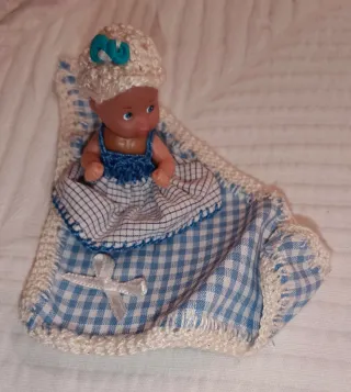 Cuna de mimbre con muñeco y accesorios