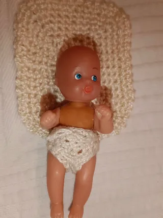 Cuna de mimbre con muñeco y accesorios