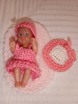 Cuna de mimbre con muñeco y accesorios