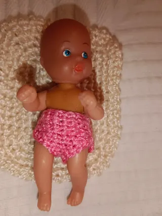 Cuna de mimbre con muñeco y accesorios